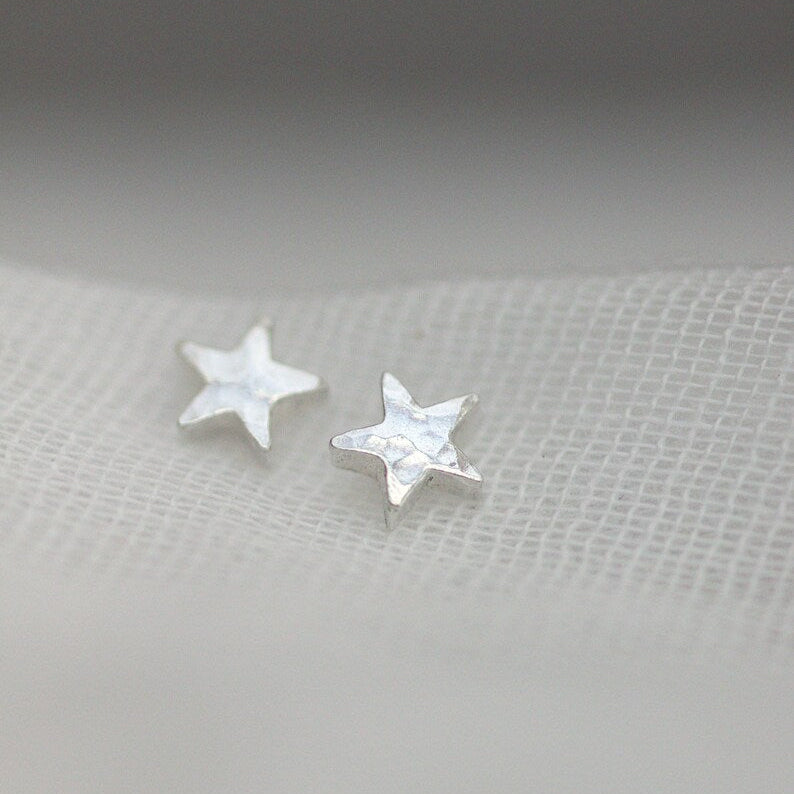 Tiny hammered silver star stud earrings threaded through fine muslin.
