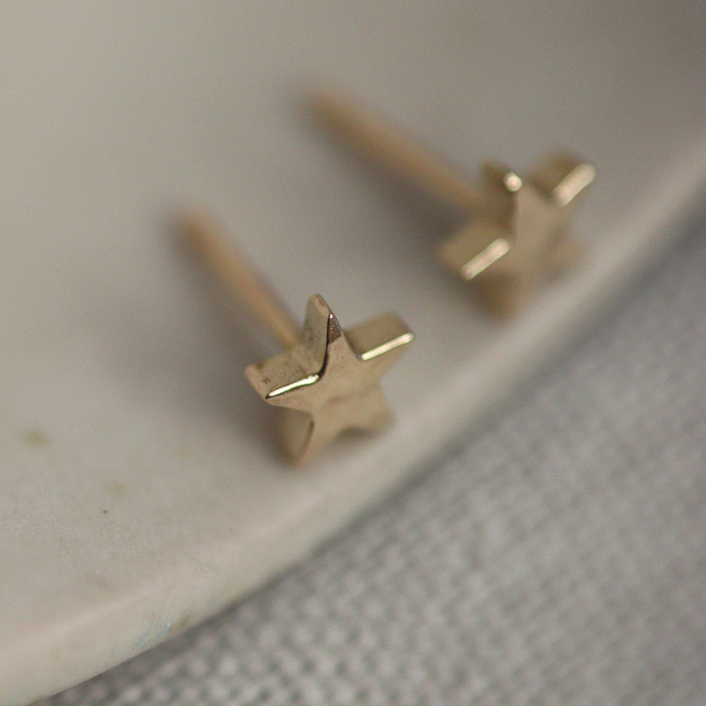 A pair of 9ct gold star-shaped stud earrings with a butterfly back and an ear pin.