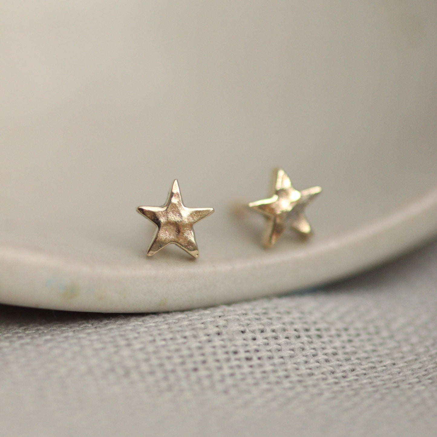 Tiny 9ct gold star studs with a lightly hammered surface.