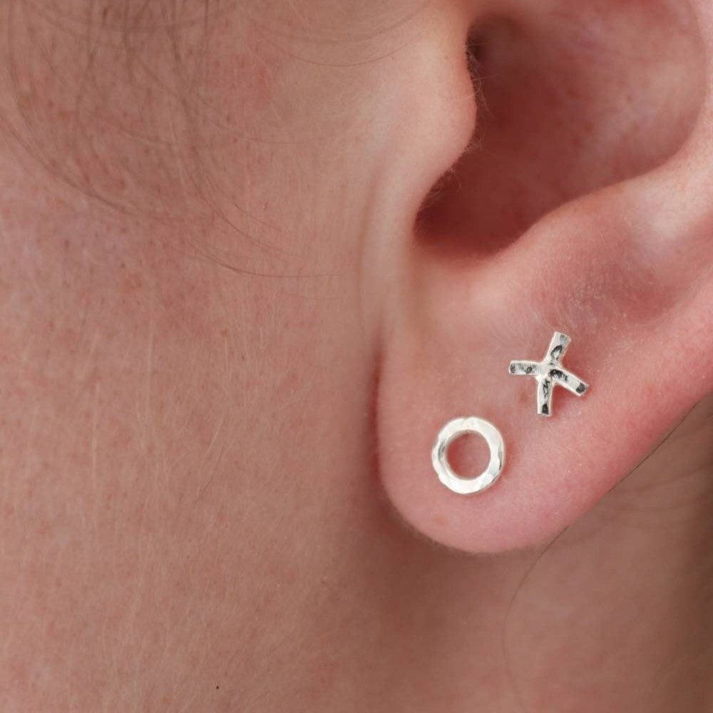 Silver hug and kiss stud earrings worn in the first and second piercings to show the asymmetrical design.