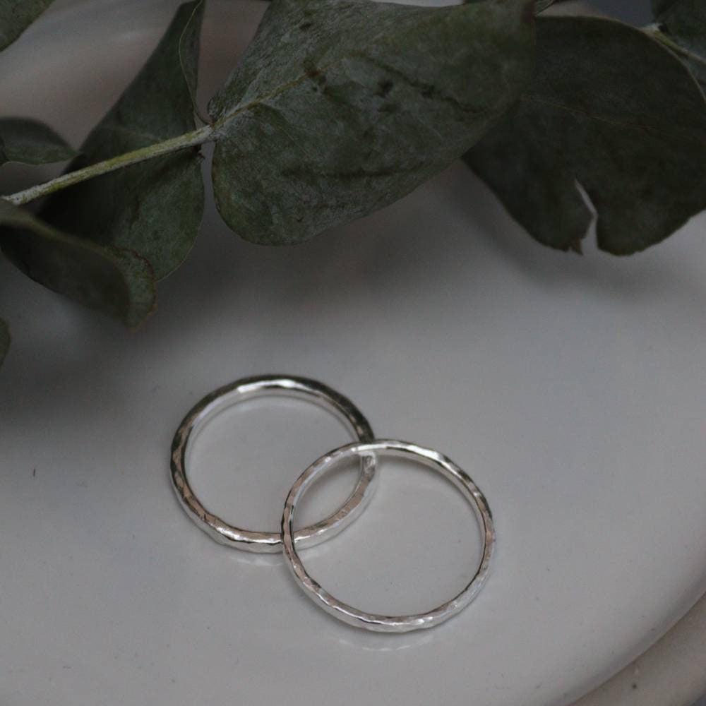 silver stacking rings on a dish with eucalyptus.