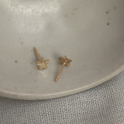 9ct yellow gold star studs on a ceramic bowl showing the ear pin.
