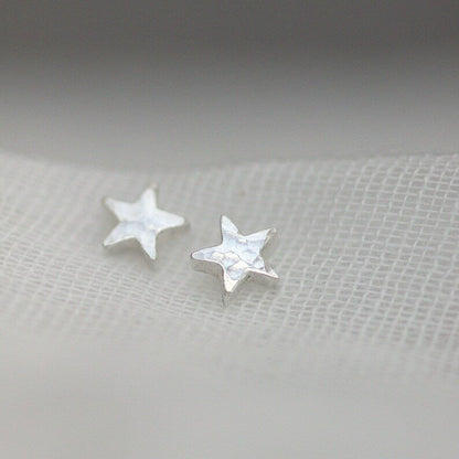 Tiny hammered silver star stud earrings threaded through fine muslin.