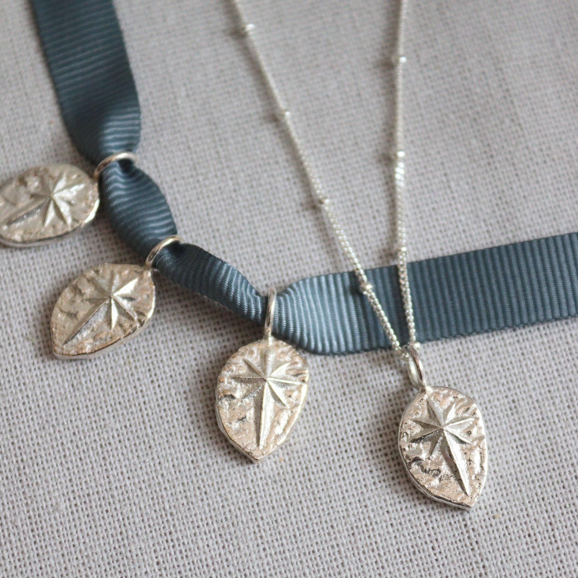  a collection of 4 silver north star pendants all ever so slightly different from the casting process.