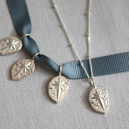  a collection of 4 silver north star pendants all ever so slightly different from the casting process.