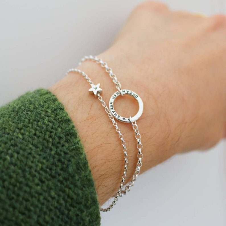 Personalised Silver bracelet with star and circle design on a wrist against a neutral background