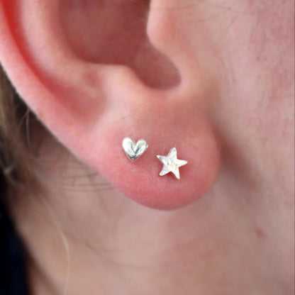Tiny Silver Heart Stud worn with a matching size silver star stud in the first and second piercing.