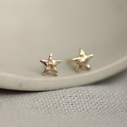 Tiny 9ct gold star studs with a lightly hammered surface.