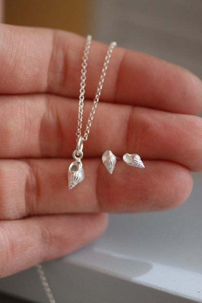 Tiny whelk earrings shown alongside a dorset whelk necklace in silver.