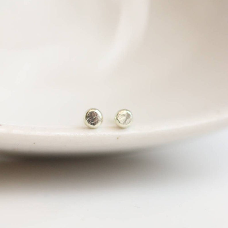 Tiny white gold stud earrings with slight hammered texture