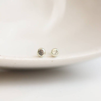 Tiny white gold stud earrings with slight hammered texture