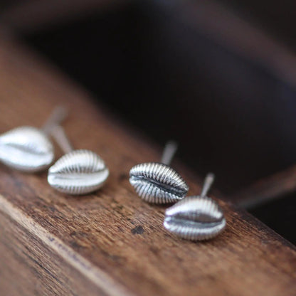 Seashell earrings shown in a group, all silver in colour with some blackened to show off the detail.
