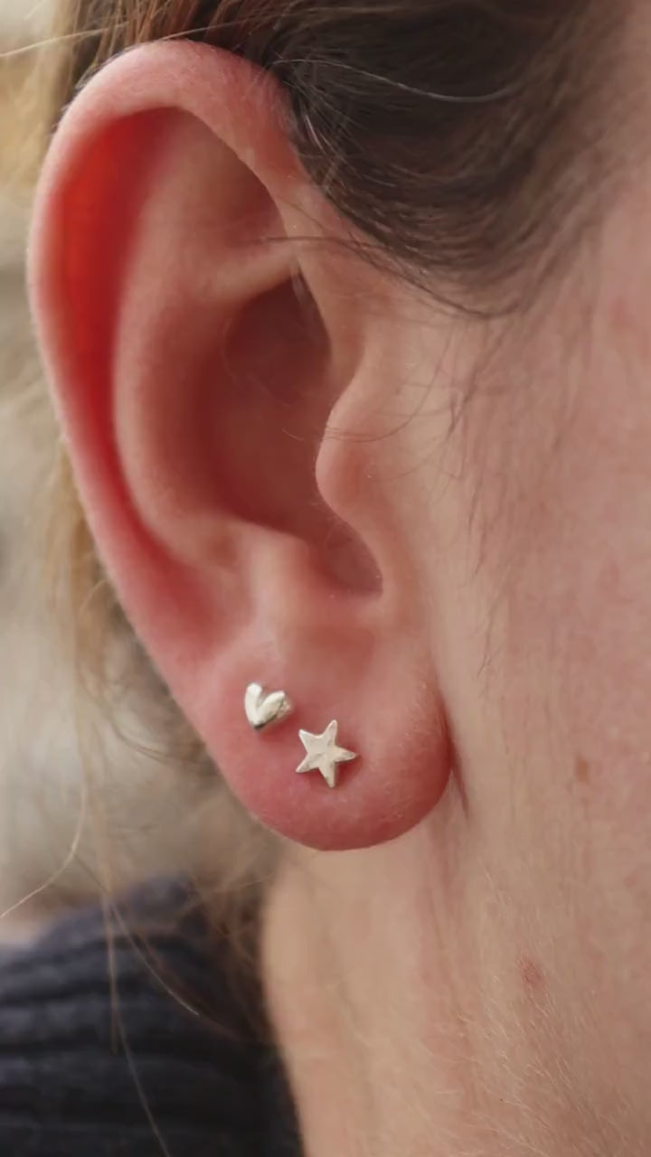 Silver heart and star studs shown in an ear from all angles