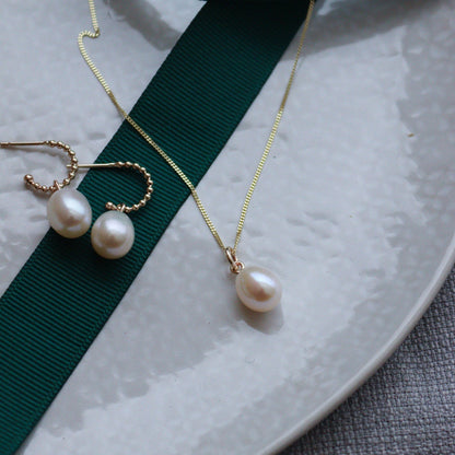 a gold chain with large pearl drop and a pair of gold beaded huggies with large pearl drops.