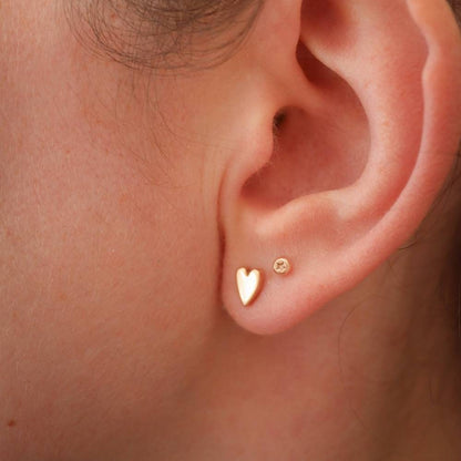 tiny gold studs with star design in a second piercing