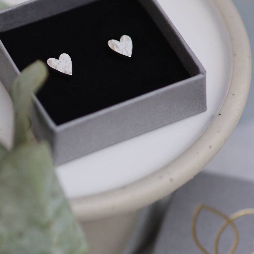 large silver heart shaped studs in a grey branded jewellery box 