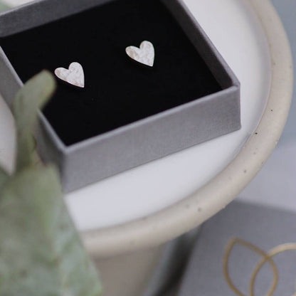 large silver heart shaped studs in a grey branded jewellery box 