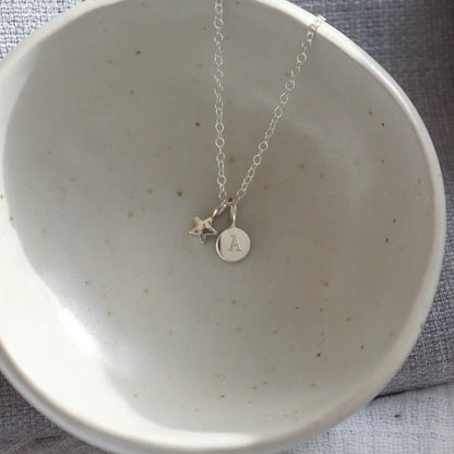 Pebble pendant imprinted with an A along with a star pendant