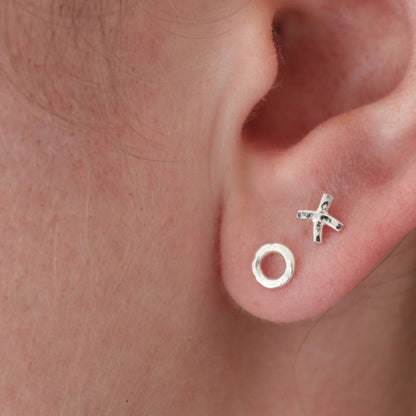 Silver hug and kiss stud earrings worn in the first and second piercings to show the asymmetrical design.