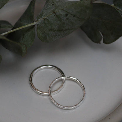 silver stacking rings on a dish with eucalyptus.